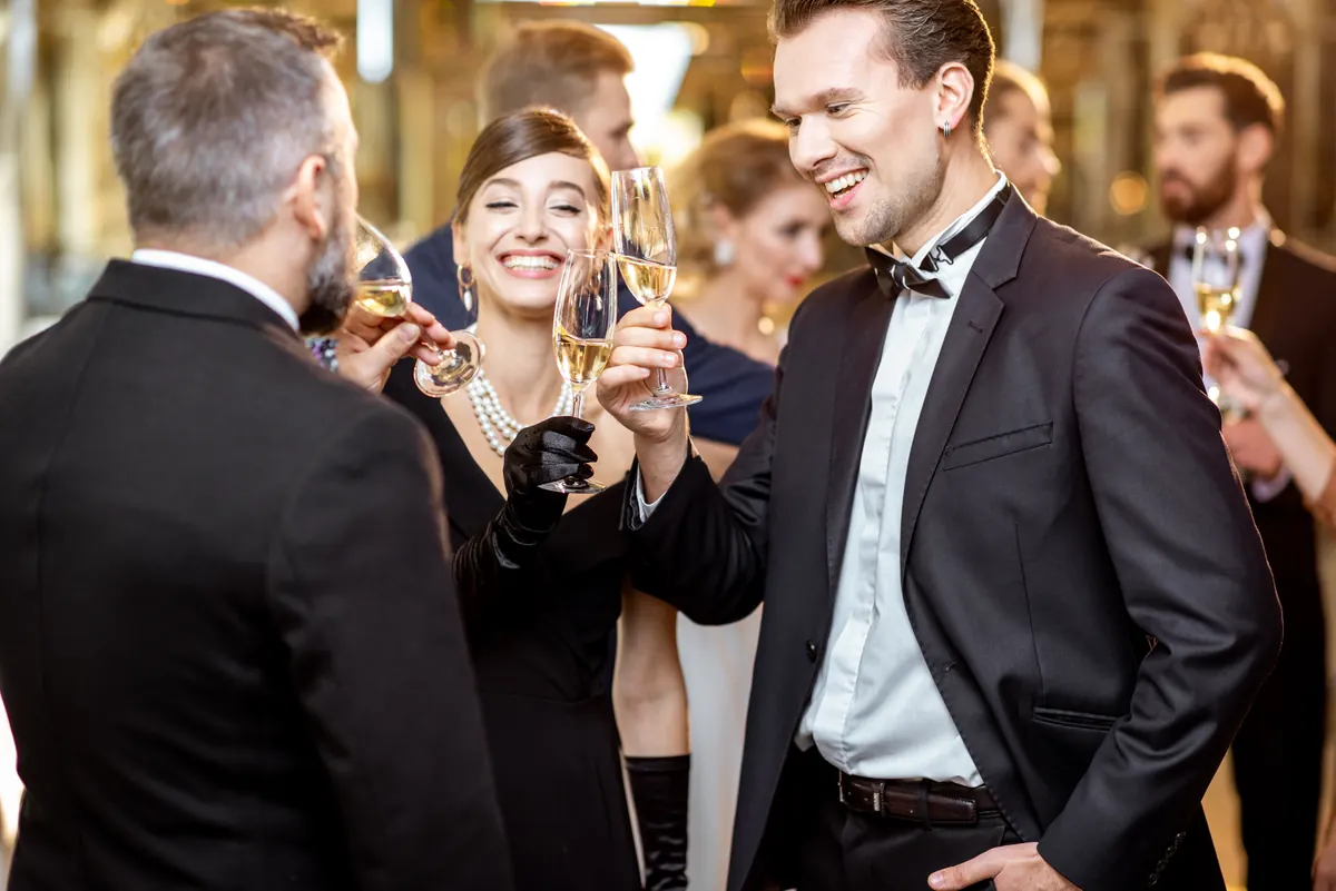 Guests in black tie raising a toast with champagne